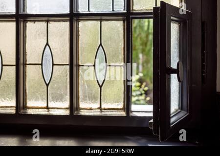 Selektiver Fokus auf teilweise öffnende alte klassische Vintage-Fenster im Treppenhaus. Stockfoto