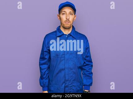 Glatze Mann mit Bart tragen Baumeister Jumpsuit Uniform entspannt mit ernster Ausdruck auf dem Gesicht. Einfach und natürlich Blick auf die Kamera. Stockfoto