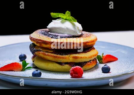 Gesundes Sommerfrühstück, hausgemachte klassische amerikanische Pfannkuchen mit frischen Beeren und Honig Stockfoto