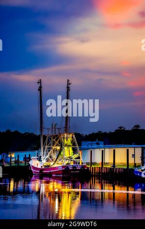 In der Dämmerung wird ein Garnelenboot beleuchtet, während sich die Besatzung auf eine lange Nacht mit Garnelen am 24. Juli 2021 in Bayou La Batre, Alabama, vorbereitet. Stockfoto