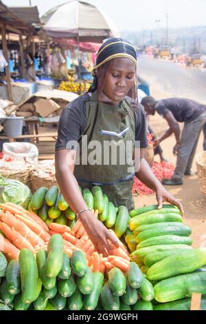 Stock Foto von weiblichen afrikanischen Lebensmittelverkäufer oder Geschäftsfrau mit Schürze, an ihrem Stand in einem Markt, bereit, an Kunden zu verkaufen Stockfoto