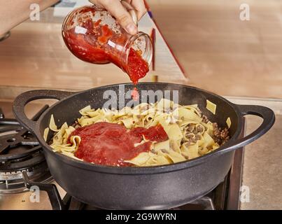Fügt Spaghetti mit gemahlenem Rindfleisch Tomatensauce hinzu, gebraten in Spaghetti Bolognese Pfanne nach Rezept aus dem Internet Stockfoto