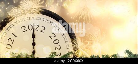 Neujahr 2022 Uhr und Feuerwerk Hintergrund. Stockfoto