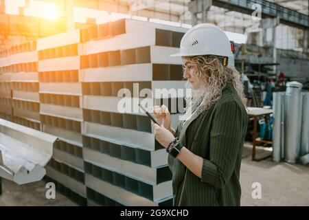 Schöne Ingenieurin steht und fotografiert die Anlage Stockfoto