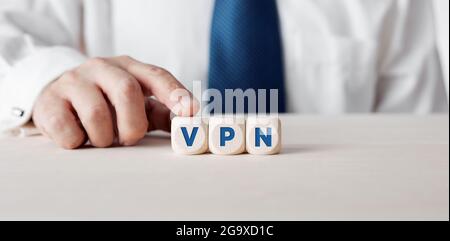 Geschäftsmann drückt seinen Finger auf die Holzwürfel mit dem Wort VPN Virtual Private Network. Stockfoto