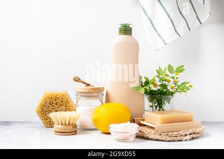 Umweltfreundliche Naturreiniger, Glas mit Backpulver, Spülbürste, Zitrone, Blumen, Seife auf weißem Hintergrund. Bio-Zutaten für selbstgemachte Reinigung Stockfoto
