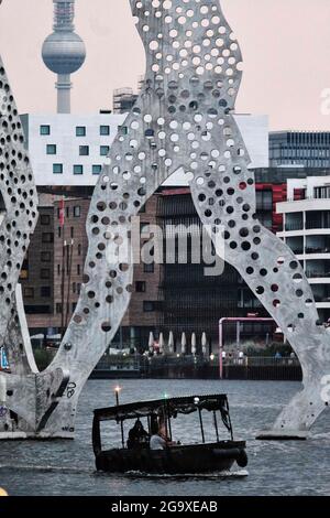 Berlin, Deutschland. Juli 2021. An einem warmen Sommerabend segelt ein kleines Boot entlang der Spree zu Füßen der Monumetalskulptur 'Molecule man'. Quelle: Stefan Jaitner/dpa/Alamy Live News Stockfoto