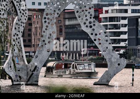 Berlin, Deutschland. Juli 2021. An einem warmen Sommerabend segelt ein Ausflugsboot mit der Aufschrift „Berlin, you are so wonderful“ entlang der Spree zu Füßen der Monumetalskulptur „Molecule man“. Quelle: Stefan Jaitner/dpa/Alamy Live News Stockfoto