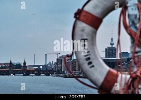 Berlin, Deutschland. Juli 2021. Blick von der Elsenbrücke über die Spree zur Oberbaumbrücke. Auf der rechten Seite des Bildes ist der Berliner Fernsehturm durch einen Rettungsring der Feuerwehr mit der Aufschrift 'Berliner' zu sehen. Quelle: Stefan Jaitner/dpa/Alamy Live News Stockfoto