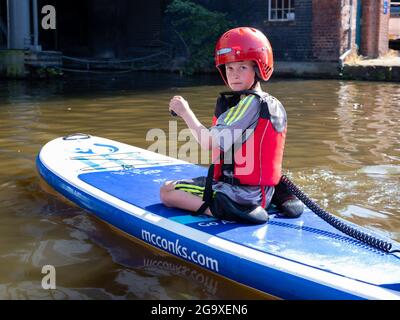 Junge auf einem Paddelbrett am Victoria Quay, am Anfang des Sheffield und Tinsley Canal, Sheffield. Stockfoto
