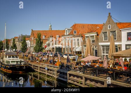 Enkhuizen, Niederlande - 2. September 2020. Gemütliche Terrassen am Hafen von Enkhuizen mit historischen Fassaden und Gebäuden im Hintergrund. Stockfoto