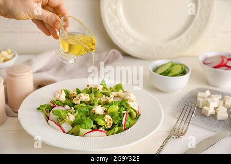 Frau macht leckeren Popcornsalat auf dem Tisch Stockfoto