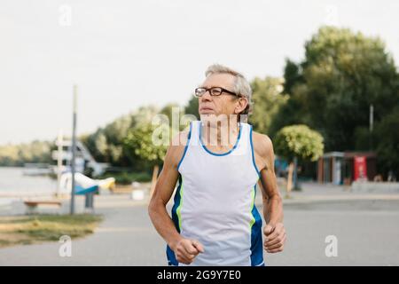 Der ältere Mann läuft an der frischen Luft Stockfoto