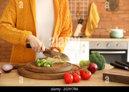 Frau schneidet Kohl in der Küche Stockfoto