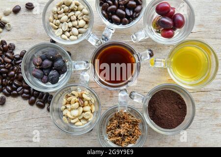 Blick von oben auf verschiedene Tassen mit Kaffee, Kaffeebeeren und Kaffeebohnen Stockfoto