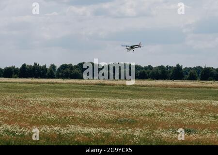 Flugzeug, das am Himmel über dem Flugplatz fliegt. Landung auf dem Flugplatz. Extrem aktiver Sport. Kleine Luftfahrt Extremsport Freizeitbeschäftigung. Stockfoto