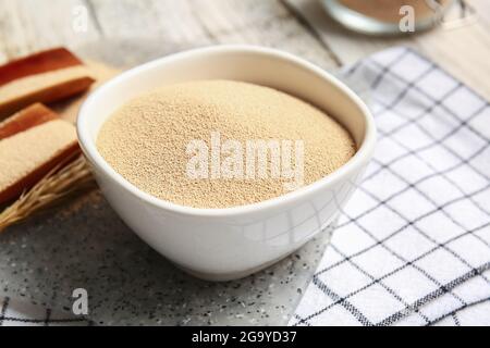 Schüssel mit aktiver Trockenhefe auf dem Tisch Stockfoto