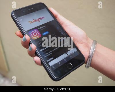 KALKUTTA, INDIEN - 26. Jul 2021: Mann mit iphone 7 plus und zeigt appstore Instagram-Anwendung auf dem Bildschirm. Instagram ist ein beliebter Online-Soci Stockfoto