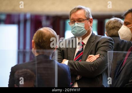 Leinfelden Echterdingen, Deutschland. Juli 2021. Manfred Döss, Mitglied des Vorstands der Porsche Automobil Holding SE und zuständig für "Legal and Compliance", steht zu Beginn des Kapitalanlegermodellverfahrens am Oberlandesgericht Stuttgart in einem Raum der Filderhalle. Das Verfahren gegen die VW-Holding Porsche SE steht im Zusammenhang mit dem Dieselskandal. Investoren werfen dem Unternehmen vor, die Märkte zu spät über die finanziellen Folgen des VW-Dieselskandals informiert zu haben. Quelle: Christoph Schmidt/dpa/Alamy Live News Stockfoto