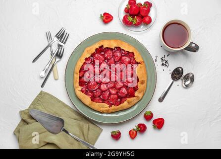 Komposition mit leckeren Erdbeerkuchen auf hellem Hintergrund Stockfoto