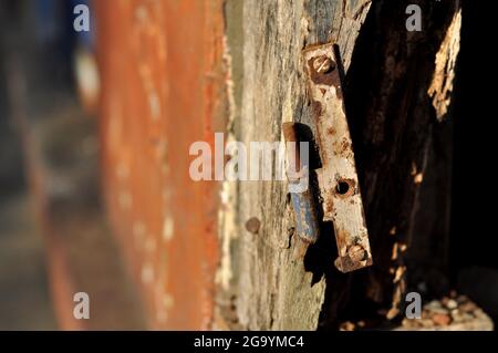 Verwitterte Türrahmenplatten und rostige Scharniere Stockfoto