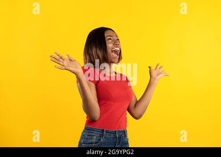 Emotionale Afrikanisch-Amerikanische Lady, Die Vor Aufregung Über Gelben Hintergrund Schreit Stockfoto