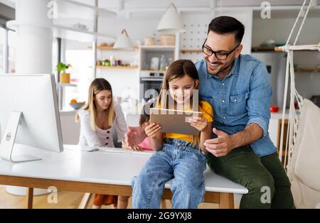 Eltern helfen Kindern, die online zu Hause studieren. Lockdown und Online-Schule, Technologie-Konzept. Stockfoto