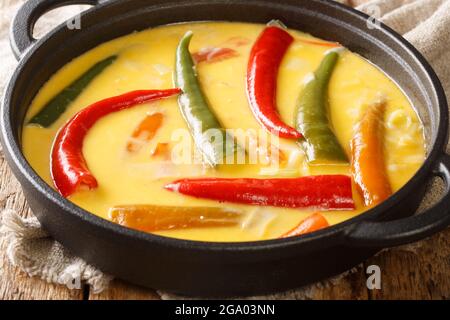 Nationalgericht von Bhutan Ema Datshi Nahaufnahme in der Pfanne auf dem Tisch. Horizontal Stockfoto