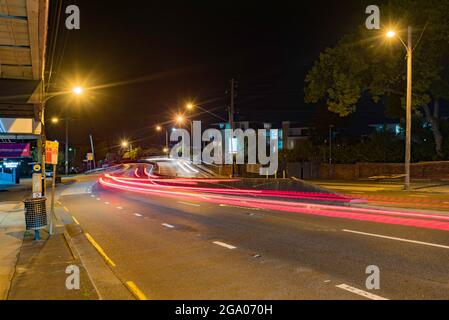 Nachts Blick auf den 6-spurigen Pacific Highway (M1) von Pymble Hill auf die Bahnüberführung in Sydney, Australien. Stockfoto