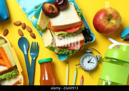 Konzept des leckeren Essens mit Lunchboxen auf gelbem Hintergrund Stockfoto