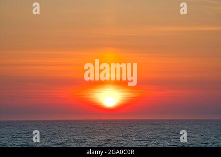 Schöner goldener Sonnenuntergang über dem See. Orangefarbenes Licht vor den Bergen. Die Fjorde Alaskas, einzigartige Naturlandschaften. Alaska, USA. Juni 2019 Stockfoto