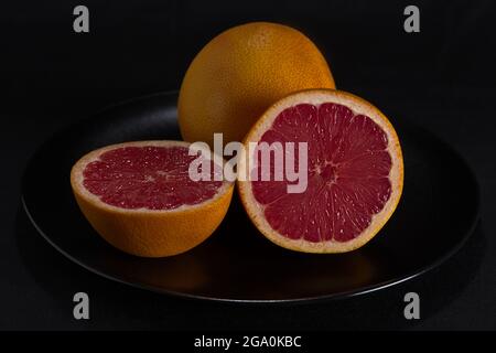 Rote Grapefruit auf schwarzem Hintergrund Stockfoto