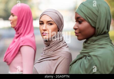 Gruppenporträt Von Drei Multirassischen Islamischen Frauen, Die Draußen Hijab Tragen Stockfoto