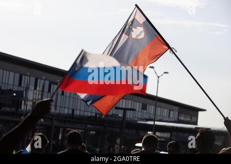 Zgornji Brnik, Slowenien. Juli 2021. Die Fans winken slowenische Flaggen, als sie auf Benjamin Savsek, den olympischen Goldmedaillengewinnerin im Kanuslalom, warten, der am Flughafen Ljubljana ankommt.am Montag gewann Benjamin Savsek Sloweniens erstes Kanuslalom-Gold bei den Olympischen Spielen in Tokio. Kredit: SOPA Images Limited/Alamy Live Nachrichten Stockfoto
