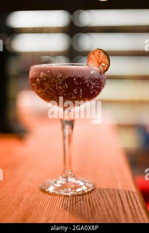 Klassischer Cocktail mit Limonensauer-Dekoration an der Theke im Restaurant Stockfoto