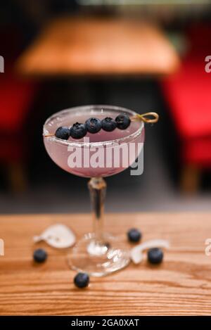 Klassischer Cocktail mit Beerenblaubeerdekor an der Theke eines Restaurants Stockfoto