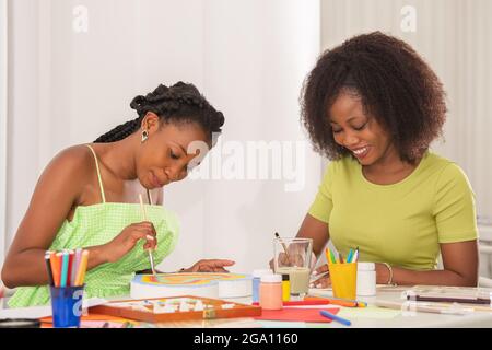 Afroamerikanische Frauen malen im Kunstunterricht Stockfoto
