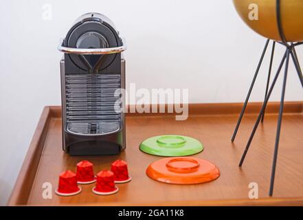 Nahaufnahme der Espressomaschine auf einem Beistelltisch aus Holz mit roten Aluminiumschoten Stockfoto