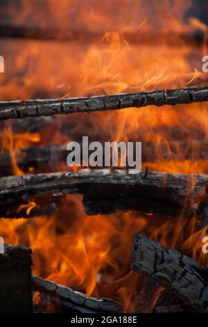 Brennendes Feuer, Nahaufnahme der Flammen. Grundlegende Elemente der Umgebung. Kamin in der Natur, im Sommer. Stockfoto