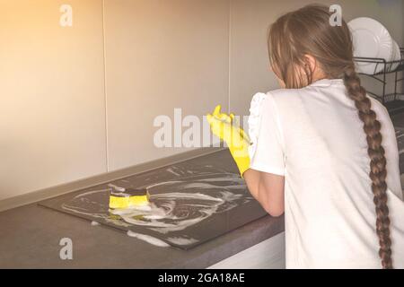 Junges Mädchen ruht während der Reinigung der Küche, Housekeeping und Sauberkeit Konzept Hintergrund, Elektroherd Pflege Stockfoto