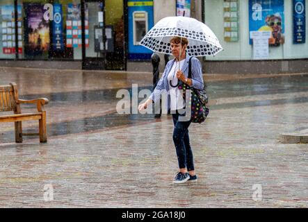 Dundee, Tayside, Schottland, Großbritannien. Juli 2021. Wetter in Großbritannien: Feuchter und bewölktes Wetter mit starken Regenausbrüchen in Nordostschottland mit Temperaturen von bis zu 21 Grad Die Anwohner werden beim Einkaufen im Stadtzentrum von Dundee von plötzlichen Ausbrüchen heftiger Regenfälle erfasst. Kredit: Dundee Photographics/Alamy Live Nachrichten Stockfoto