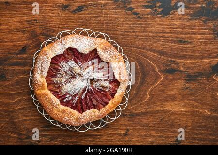 Hausgemachte Rhabarber-Galette mit Sternmuster auf altem Holztisch-Hintergrund. Backvorgang. Öffnen Sie die PIE. Weihnachten und Neujahr Backwaren. Oben Stockfoto