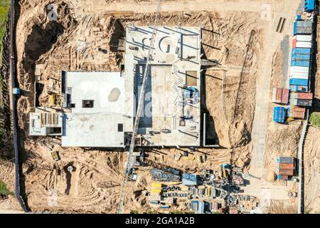 Baustelle Luftaufnahme von oben. fundamentgrube mit monolithischem Plattenfundament und Betonguss. Turmkran auf Gebäudekonstruktion. Stockfoto