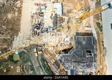 Luftaufnahme der Bauarbeiten. Bau der Fundamente auf der Baustelle mit einem gelben Kran. Stockfoto