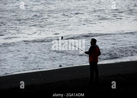 VIK, ISLAND - 21. MAI 2019: Touristen besuchen den Reynisfjara Strand und machen Selfie an der Atlantikküste Südislands in Vik Stockfoto
