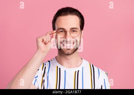 Foto Porträt Mann in T-Shirt-Brille lächelnd glücklich isoliert pastellrosa Hintergrund Stockfoto