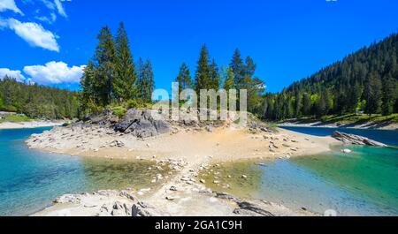 Kleine Insel mitten im Caumasee (Caumasee) mit kristallklarem Wasser in wunderschöner Berglandschaft bei Flims, Graubünden - Schweizlan Stockfoto