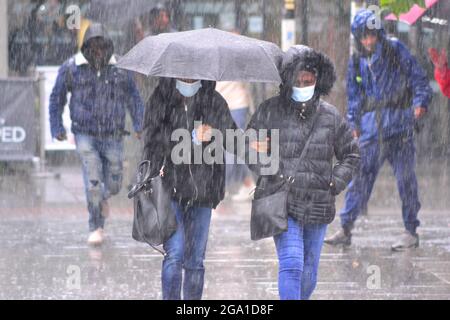 Manchester, Großbritannien. Juli 2021. UK Wetter: Gewitter und Starkregen in Manchester, UK. Die Menschen versuchen, den Regen im Stadtzentrum zu vermeiden. Quelle: Terry Waller/Alamy Live News Stockfoto