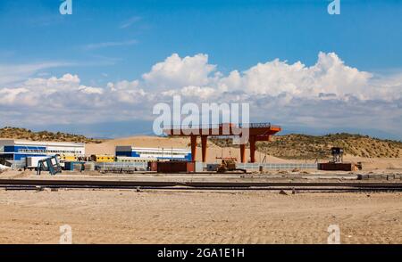 Altynkol, Kasachstan - 05. Juni 2012: Bahnhof Altynkol. Bau eines Containerverladeterminals für den Zug. Roter Portalkran und Eisenbahn. Stockfoto