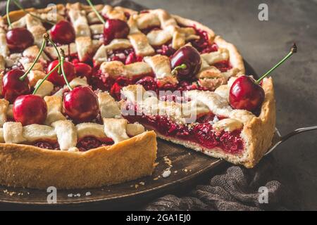 Nahaufnahme von hausgemachtem Kirschkuchen mit einem Stück, das herausragt Stockfoto